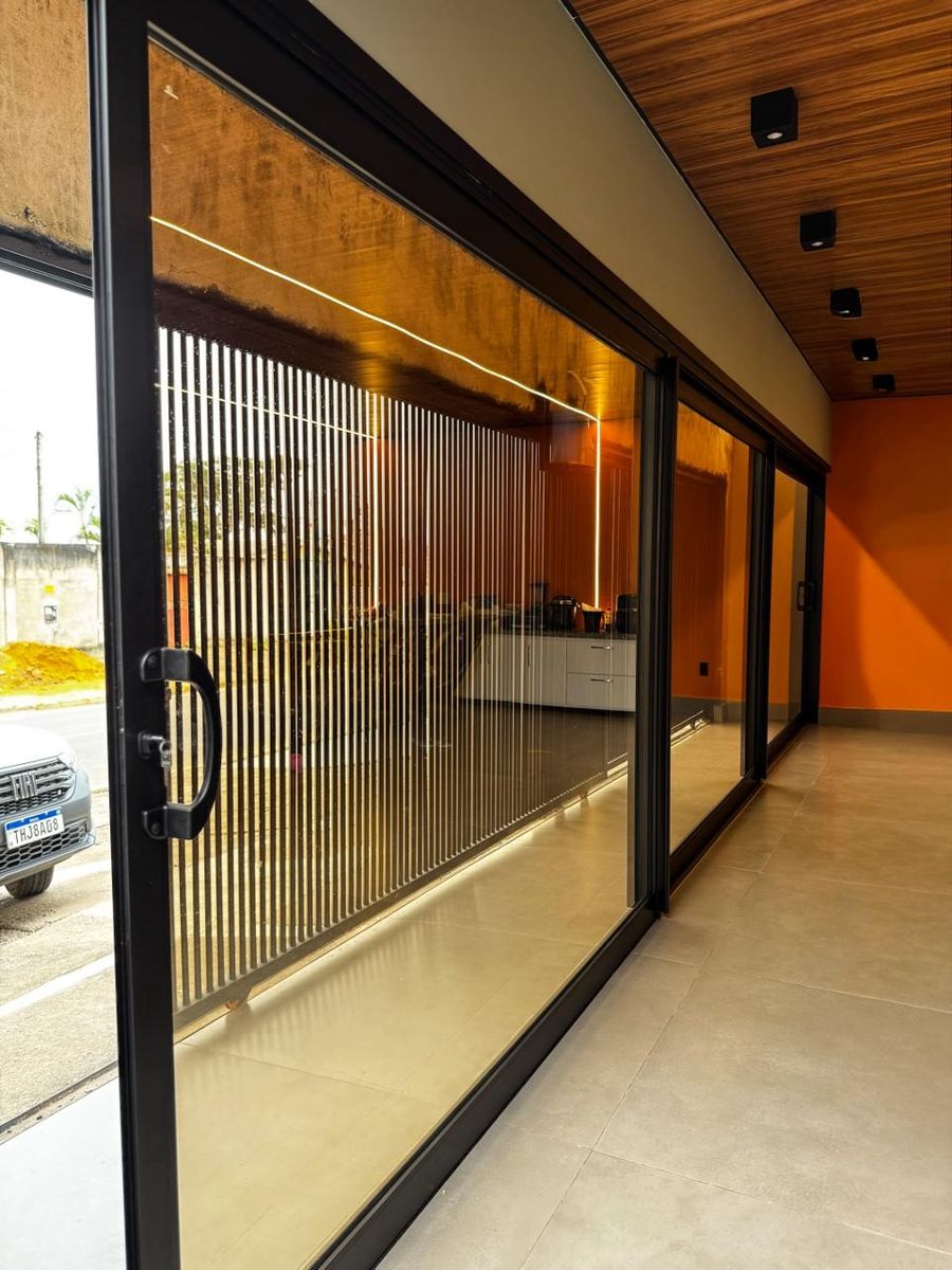 Porta de correr de vidro com esquadria de alumínio em loja comercial